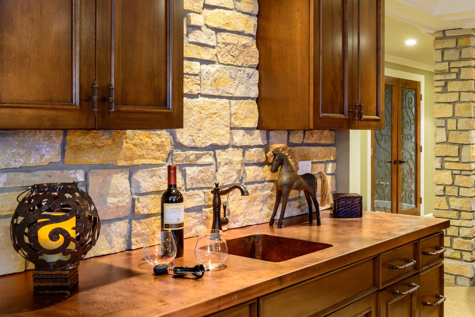A kitchen counter with a sink and a bottle of wine on it.