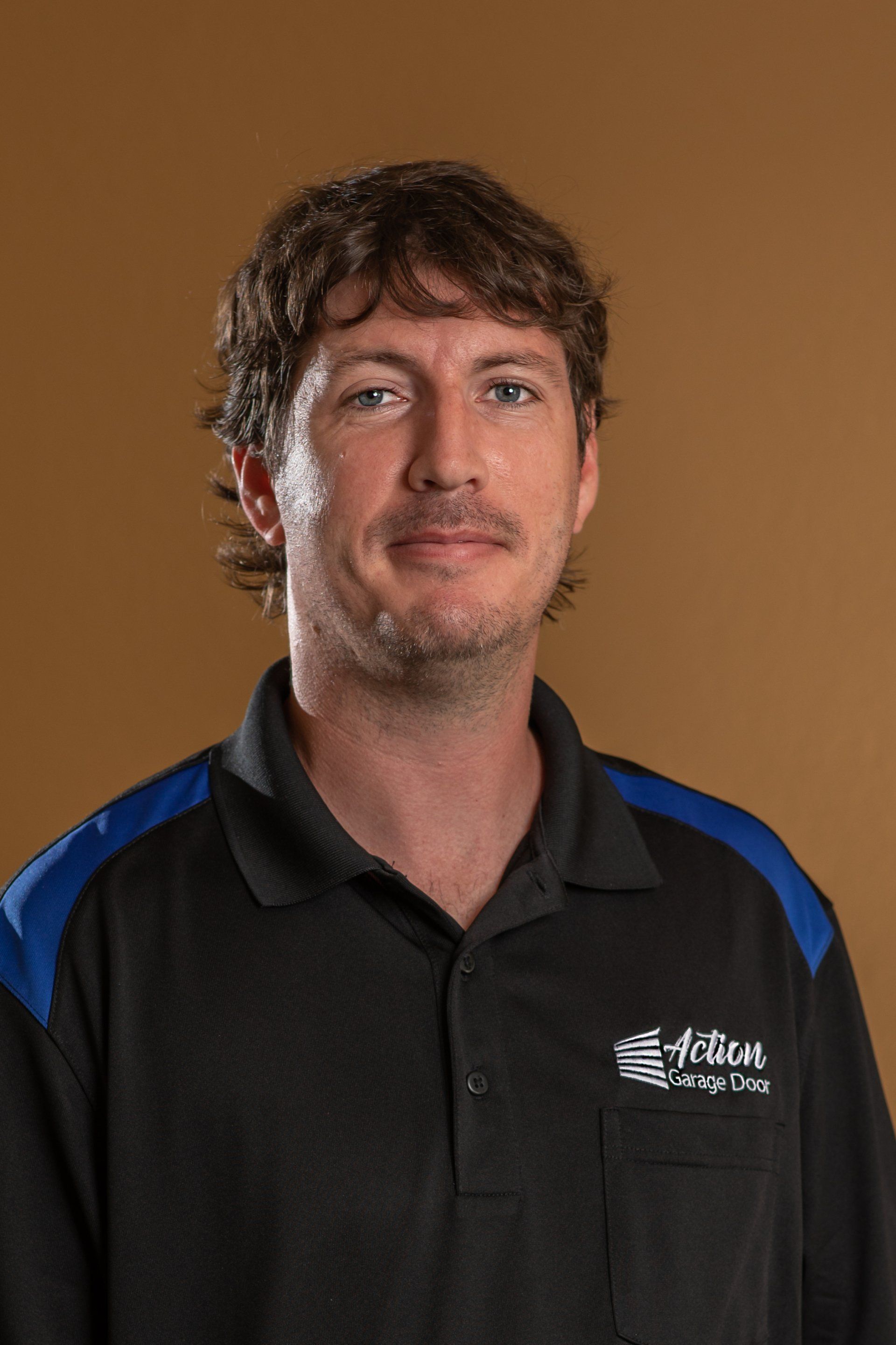Schedule an appointment with us and you'll have a chance to meet Chad as your friendly repair man! Man smiling next to Action Garage Door Services Sign in Central Arkansas
