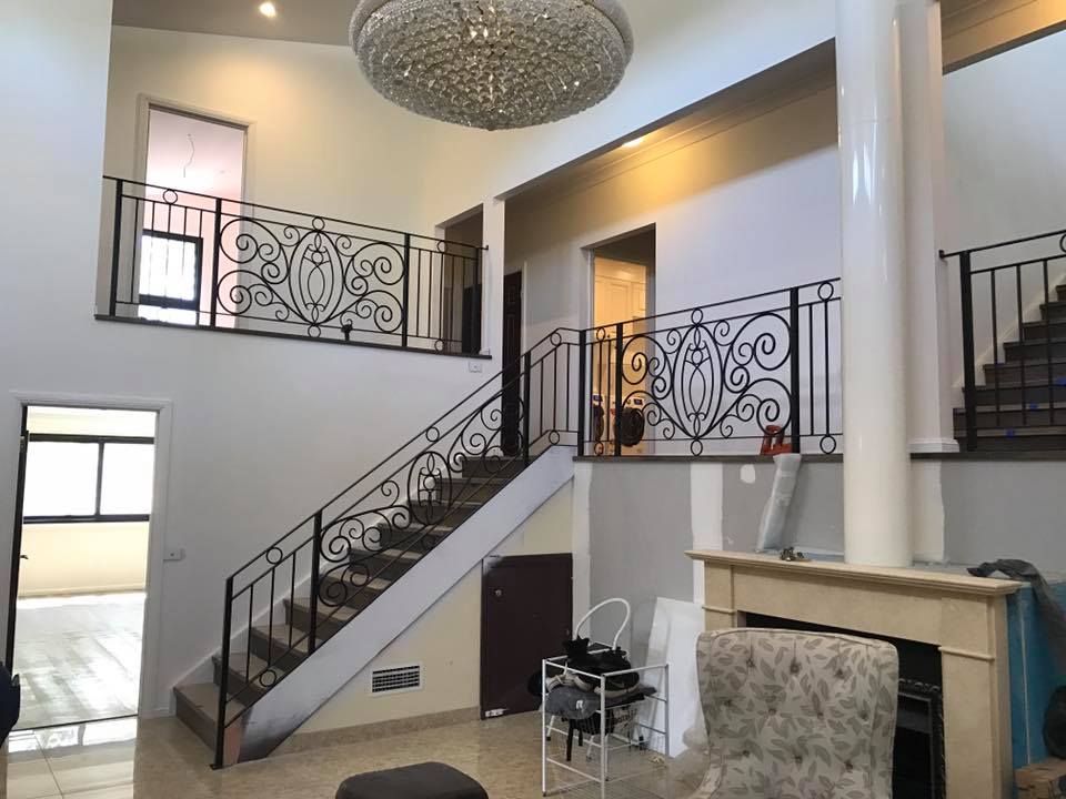A living room with stairs leading up to the second floor and a fireplace.