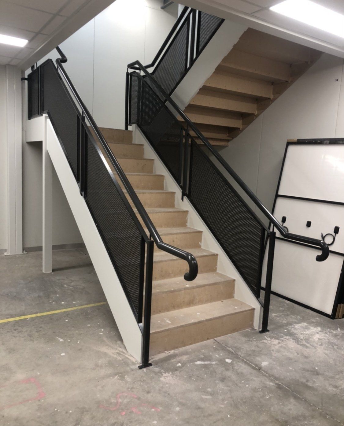A staircase with a black railing in a building