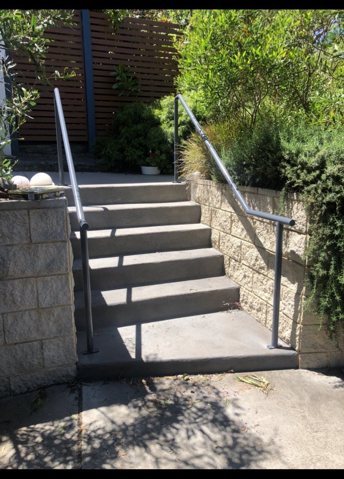 A set of concrete stairs with a metal railing