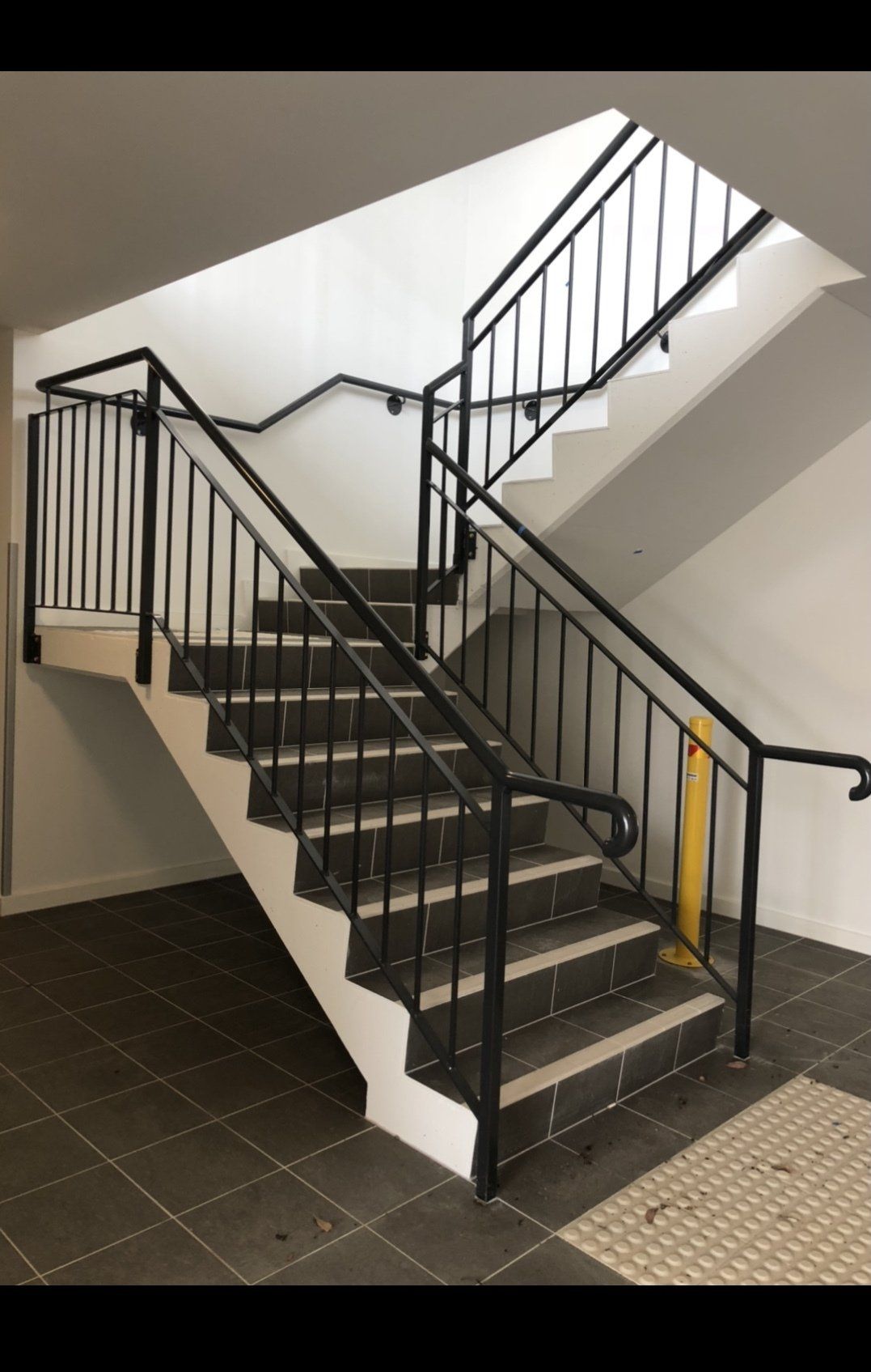A staircase with a metal railing in a building.