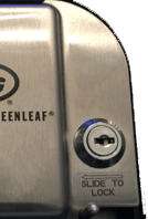 Close-up of a stainless steel lock with a blue-ringed keyhole and “SLIDE TO LOCK” label.