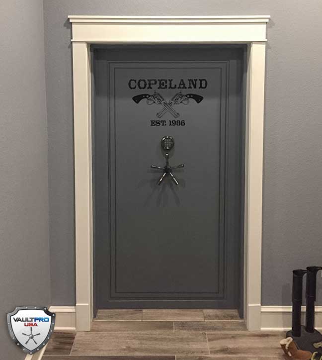 Gray front door with COPLAND sign and decorative handle in a white-trimmed entryway