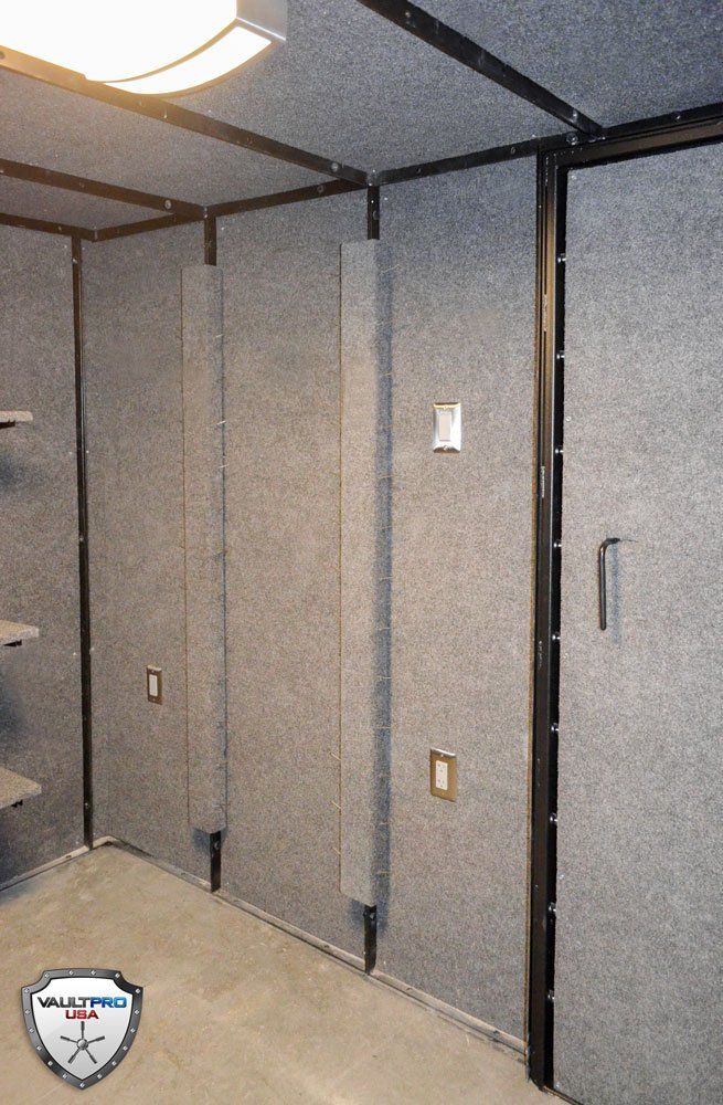 Gray padded interior walls with black framing and a closed door in a small room