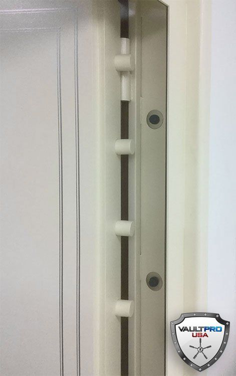 Close-up of a white door or window lock mechanism with a metal strike plate and bolts