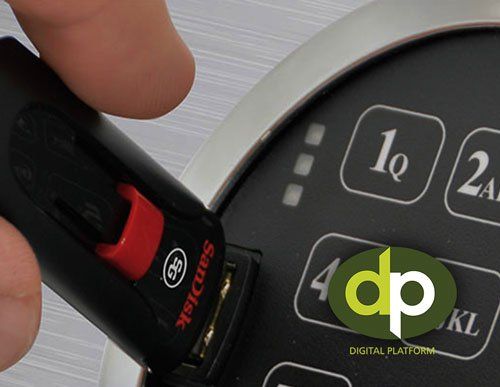 Hand pressing a black key fob toward a car’s push-button ignition
