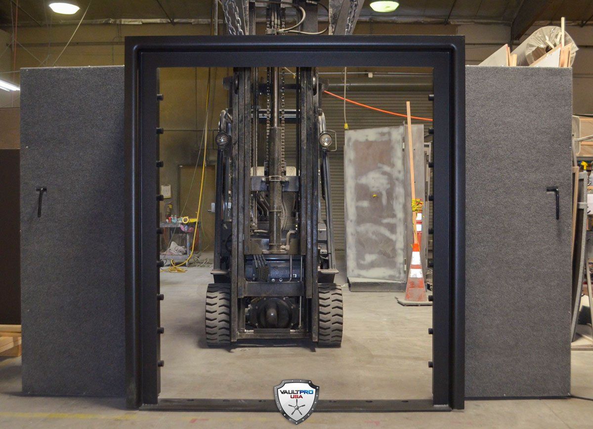 Forklift framed by a large black portal in an industrial warehouse or training area.