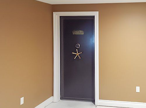 Empty tan room with a dark front door and white trim