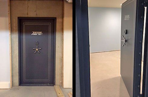 Two open safe deposit vault doors in a hallway, one closed black door and one open to a beige room.