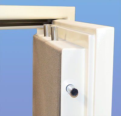 Close-up of a white door hinge or latch mechanism on a beige panel against a blue background