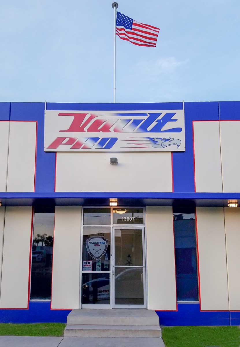 Storefront with blue and white facade, a U.S. flag above the entrance, and a logo sign over the door