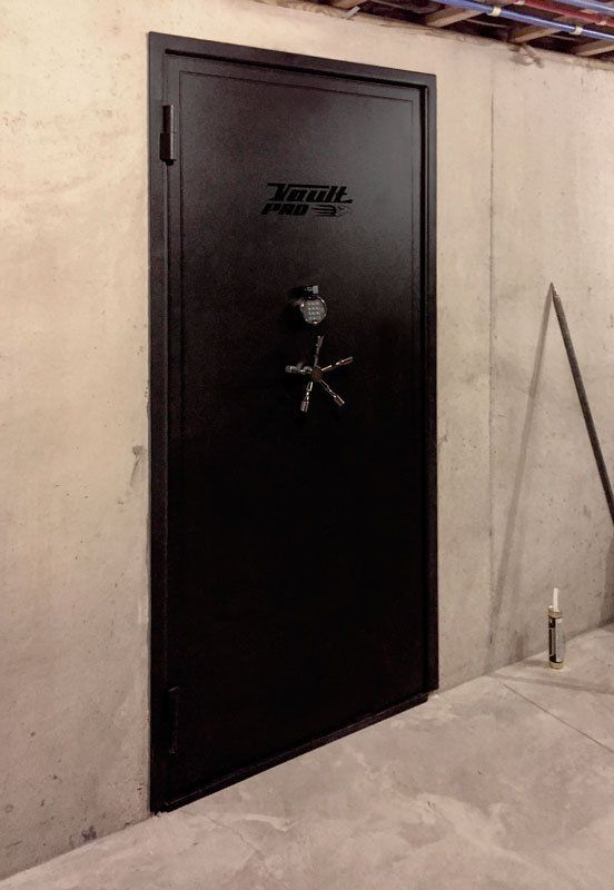 Black heavy-duty door with wheel handle set in a concrete wall indoors