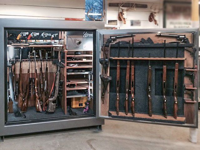 Open gun cabinets with rifles stored on racks in a room