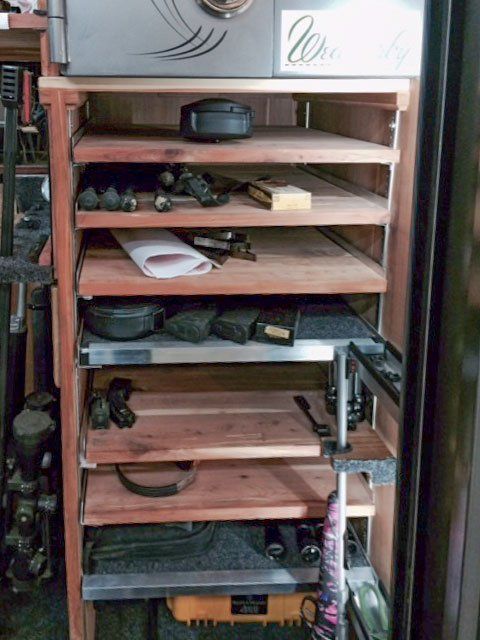 Wooden cabinet shelves packed with assorted electronics, cables, and small devices