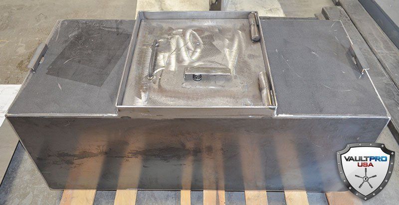 Metallic gray rectangular box with a clear center window, shown on a striped surface.
