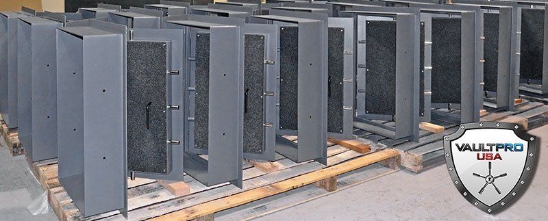 Rows of gray metal equipment cabinets on wooden pallets in a warehouse-like setting
