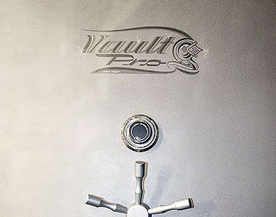 Vault Pro safe door with a round lock and chrome handle on a brushed metal surface