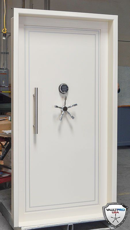 White security safe door with a combination lock and long handle, shown indoors.