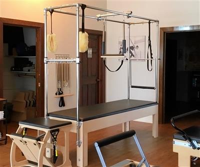 A pilates machine is in a room with a wooden floor