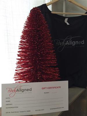 A gift certificate for body aligned is next to a christmas tree