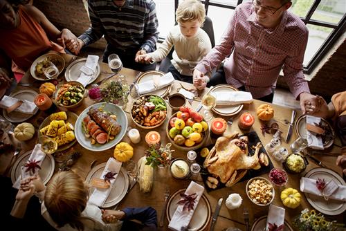 A group of people are sitting around a table with plates of food.