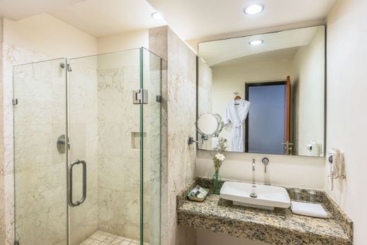 Modern bathroom with glass shower, granite vanity, sink, and large mirror