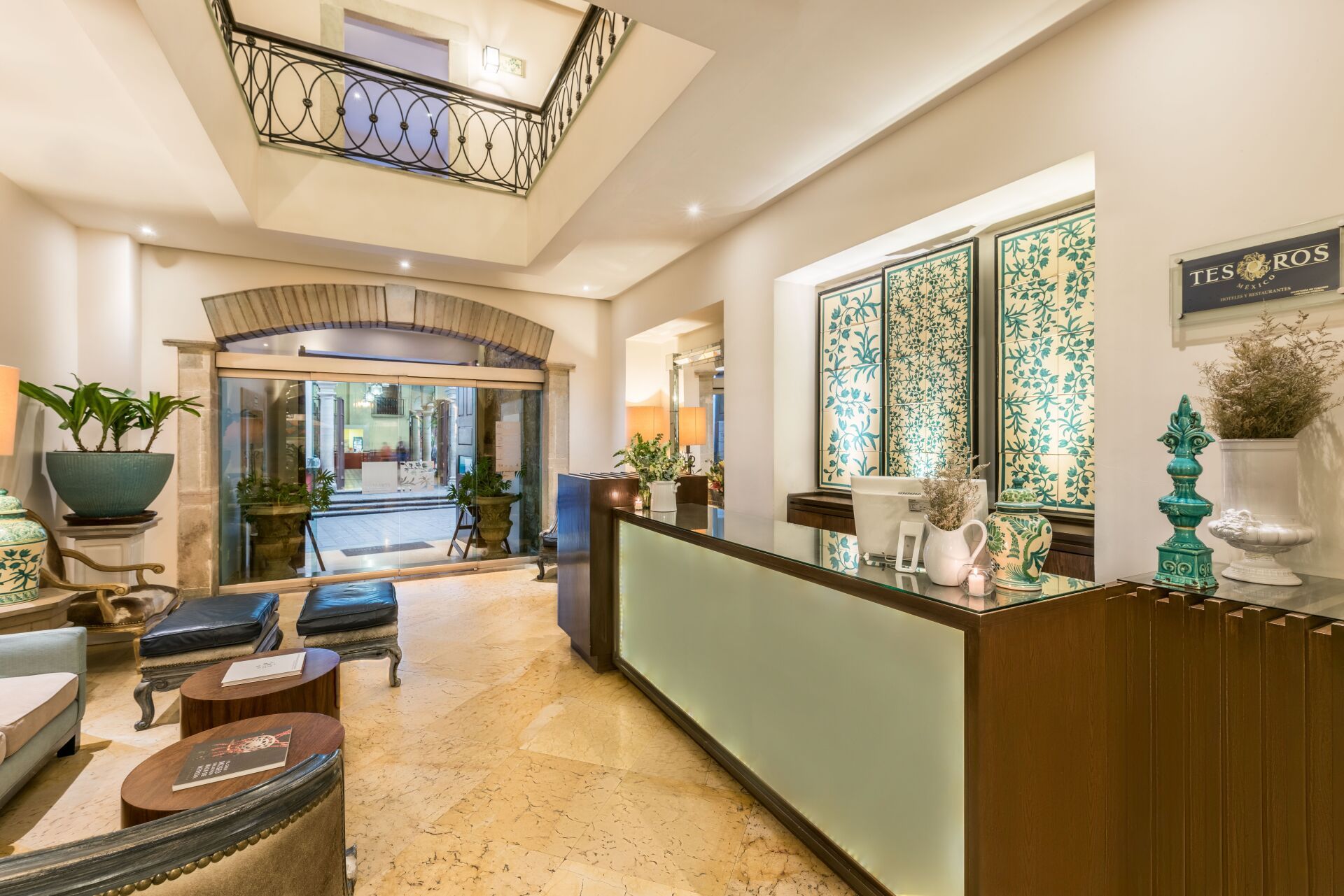Elegant hotel lobby with reception desk, seating area, and decorative skylight lighting