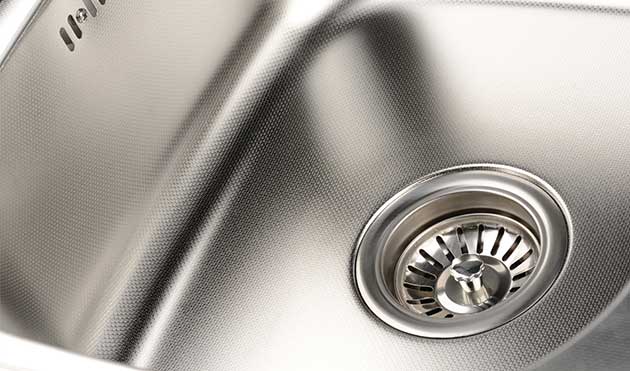 a close up of a stainless steel kitchen sink with a drain