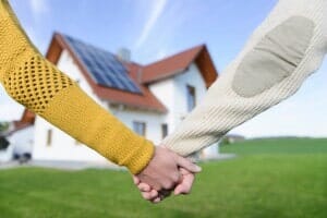 Couple holding hands in front of new home —Attorney in Longmeadow, MA Couple holding hands in front of new home —Attorney in Longmeadow, MA
