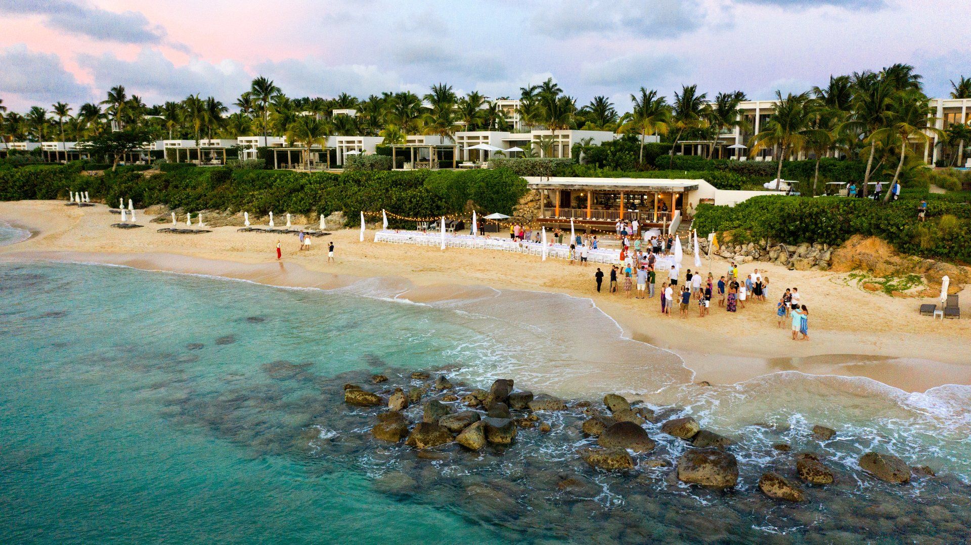 Incentive trip at tropical beach location photographed from above with a drone. Photo shows groups of people mingling on a beach before dinner. 
