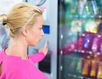Woman at Vending Machine Purchasing a Snack Woman at Vending Machine Purchasing a Snack
