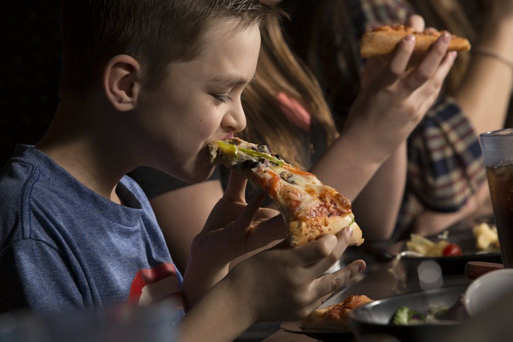 young child eating pizza at pizza madness