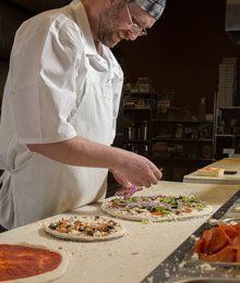 pizza chef prepping a pizza