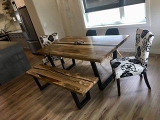 Wooden dining table with bench and patterned chairs in a bright modern room