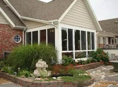 Suburban house exterior with bay windows, brick siding, and a landscaped front garden