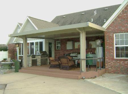 Brick house porch with wicker chairs and tables under a covered patio