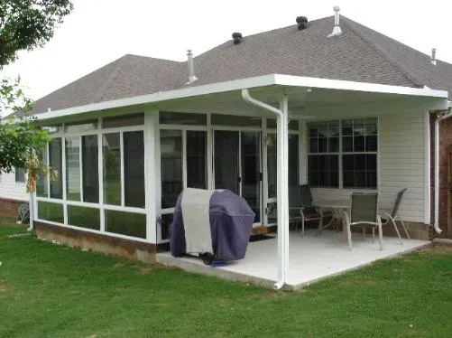 Covered patio with white screens, patio furniture, and a grill attached to a brick house