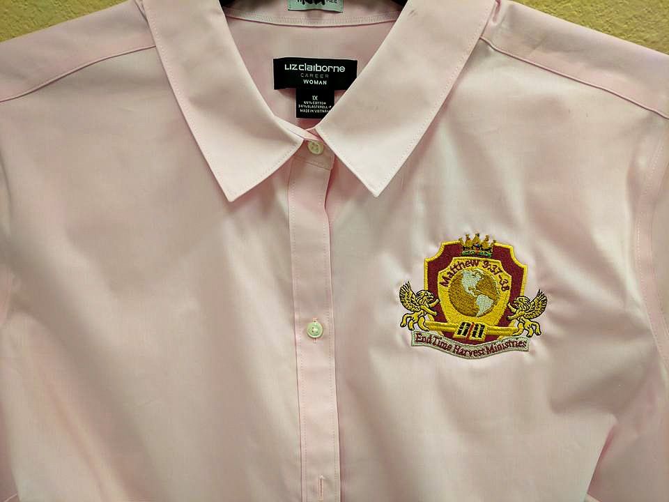 Pink button-down shirt with a crest featuring a globe and 