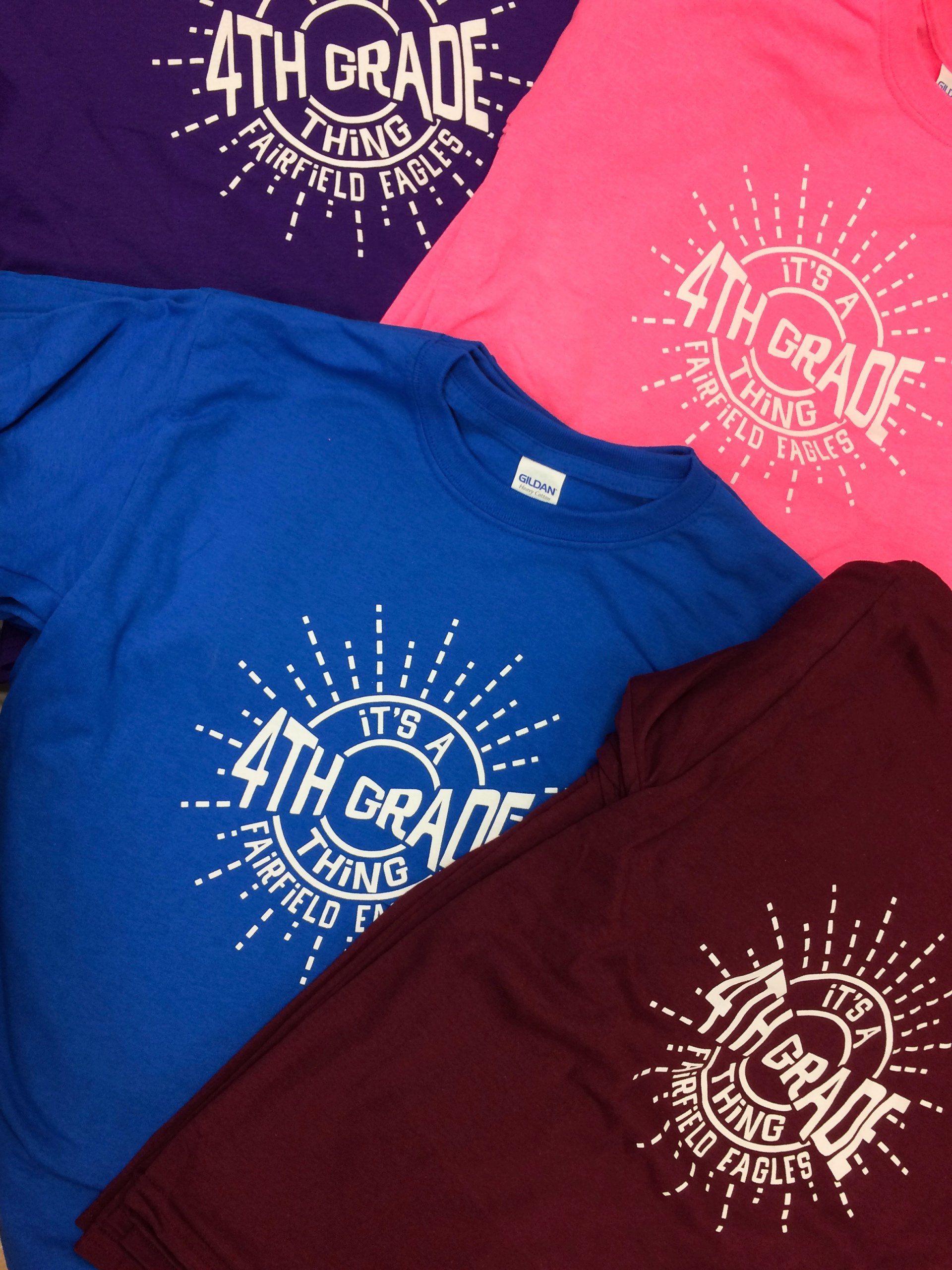 Four colorful t-shirts: purple, pink, blue, and maroon, with a white 