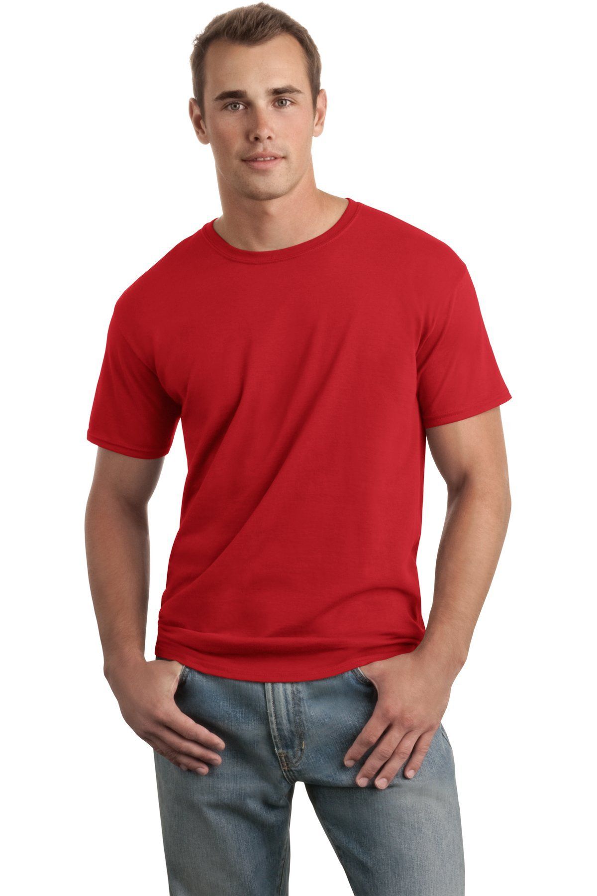 Man wearing a red t-shirt and blue jeans, standing with hands in pockets.