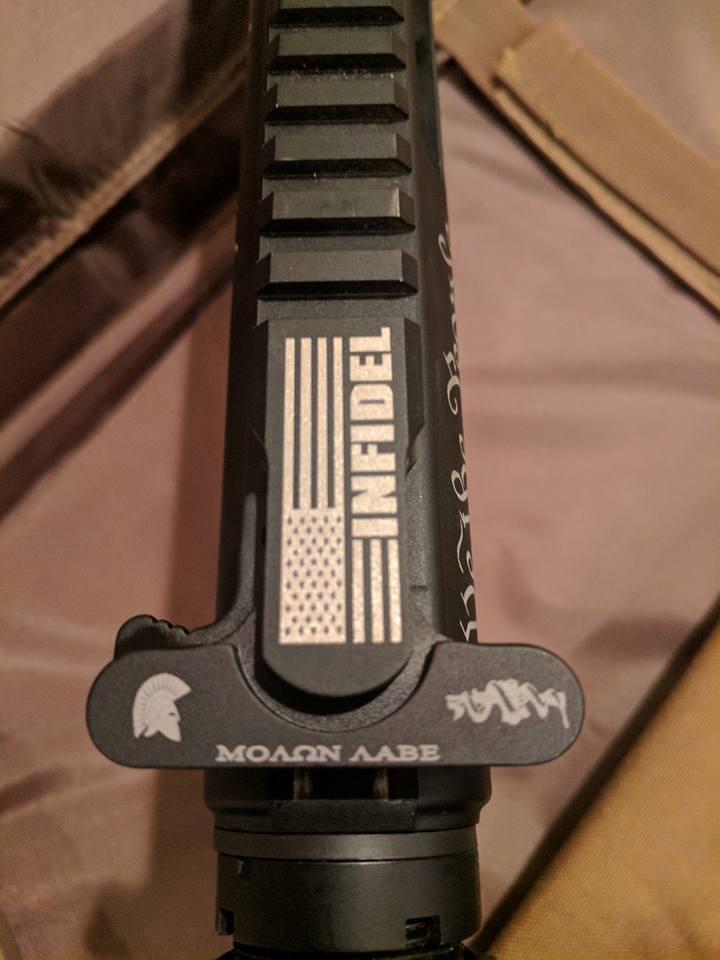 Black AR-15 rifle receiver with engraved American flag and