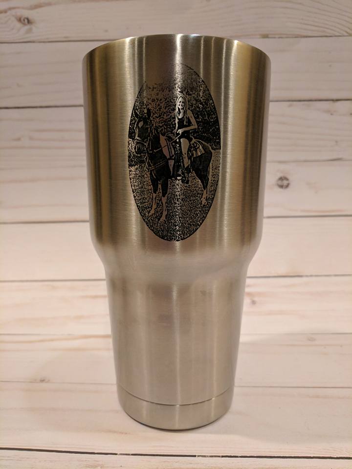 Stainless steel tumbler with engraved oval image of two horses.