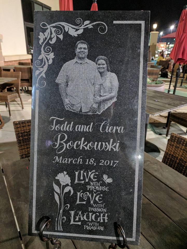 Engraved granite memorial with photo of couple, names, date, and quote:
