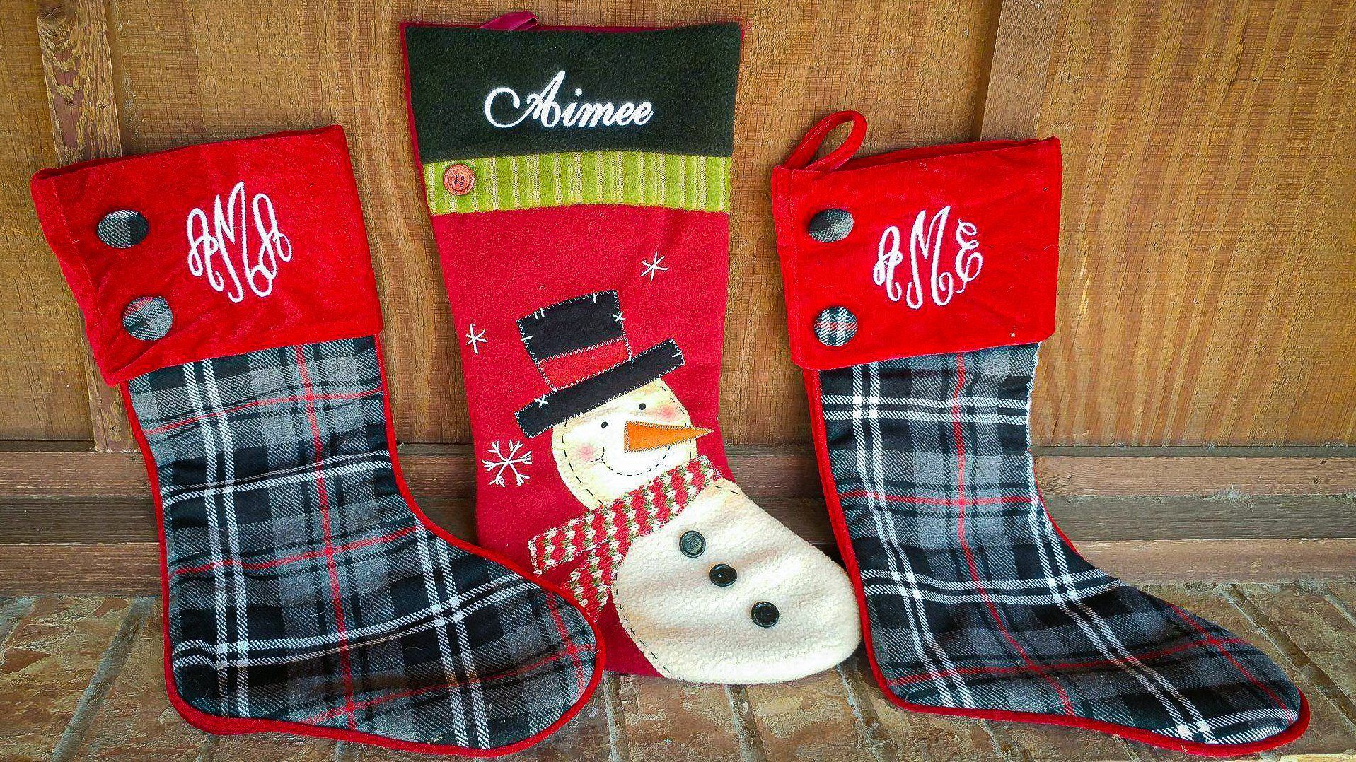 Three Christmas stockings: one snowman, two plaid, all with red cuffs.