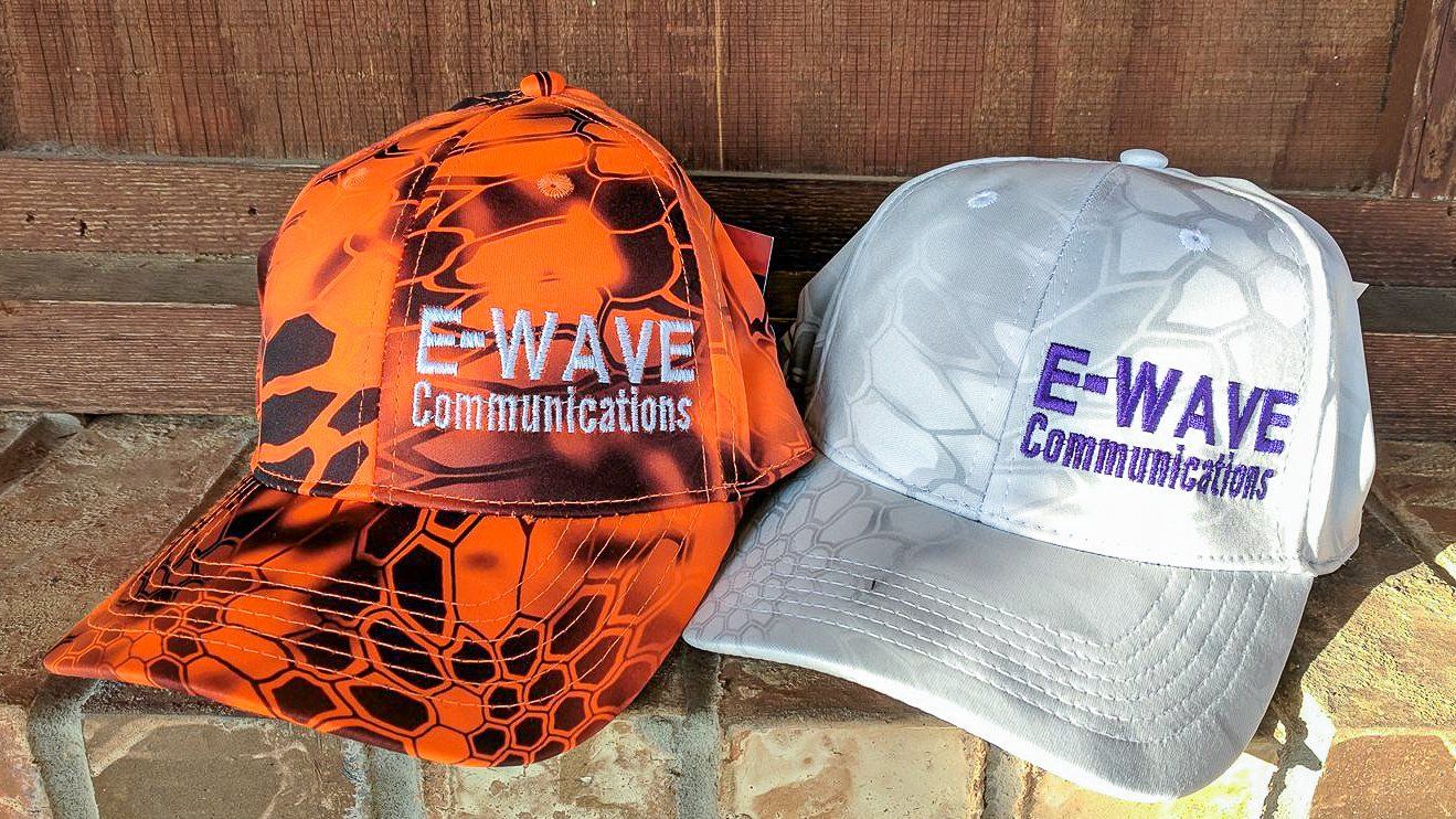 Two baseball caps, orange and white, with 