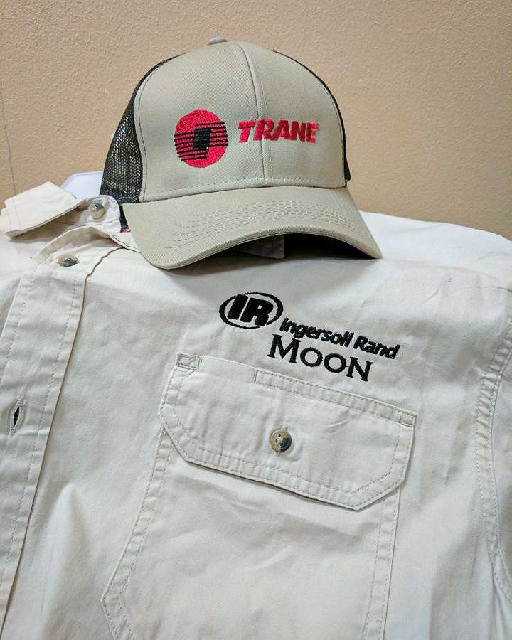 Tan Trane cap and tan button-down shirt with Ingersoll Rand logo, on a white surface.