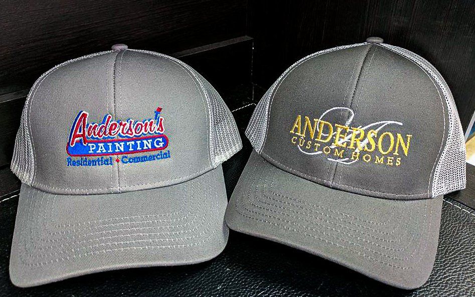 Two gray trucker hats with logos: 