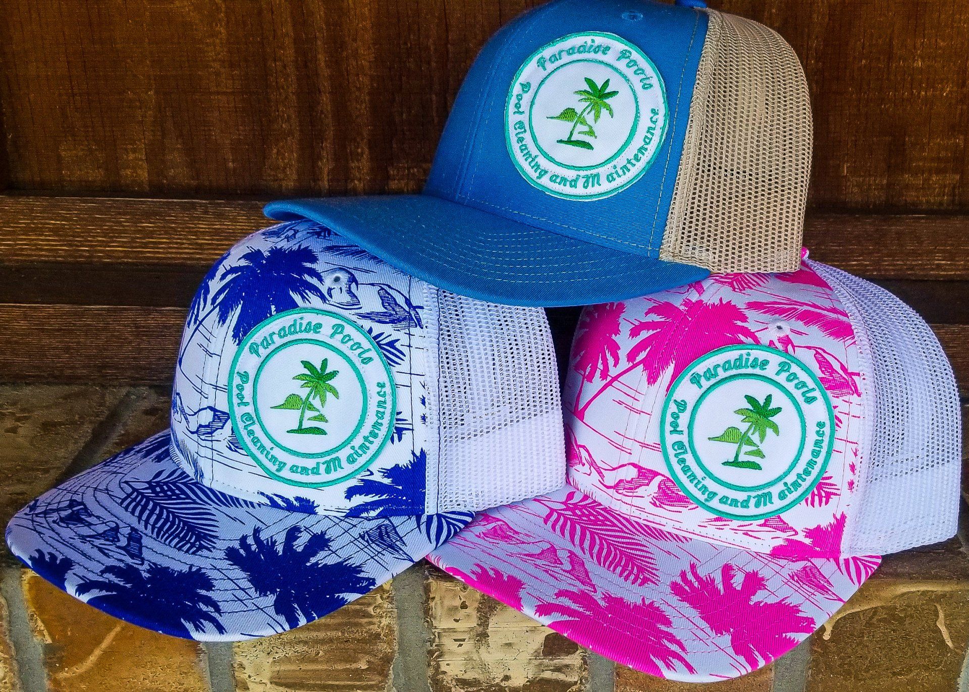 Hats with palm tree logo; blue, white, pink, and tan.
