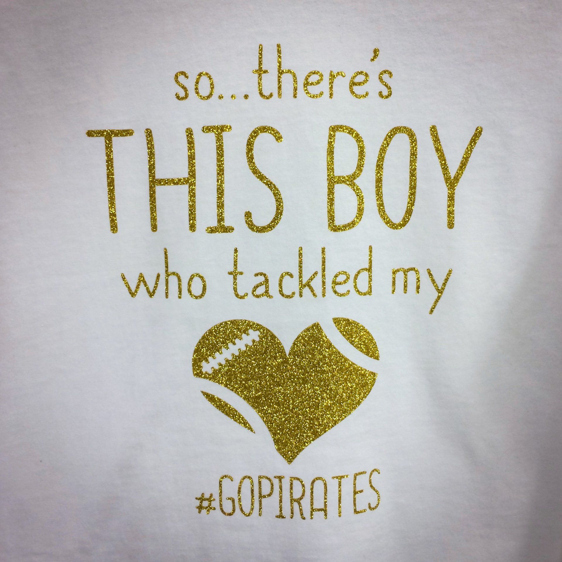 Gold glitter text on white shirt: